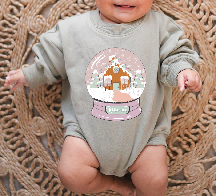 Baby wearing a onesie with a snow globe design on a textured rug